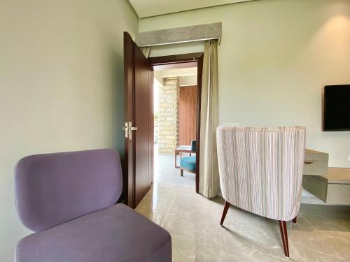a living room with a purple chair and a television at Vastu Serene Studio Apartment in Dehradun