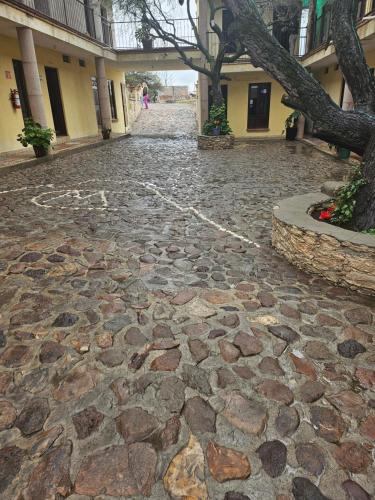 a cobblestone street with a tree and a building at Hotel villas la aurora in Bernal