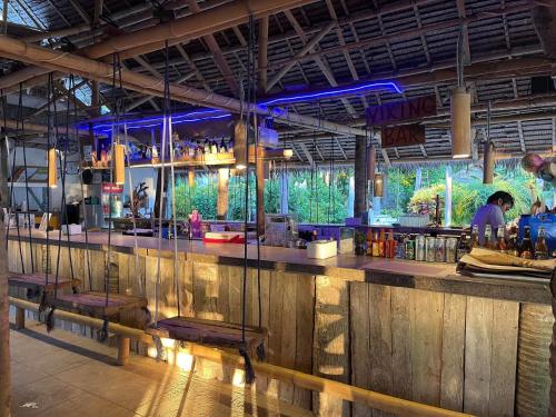 un bar avec des lumières bleues dans un restaurant dans l'établissement Pili Beach Resort Agmanic, à Santa Fe