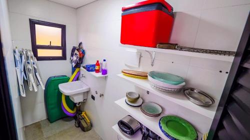 La salle de bains est pourvue de toilettes et d'étagères. dans l'établissement Chalé Amarelo, à Itanhaém