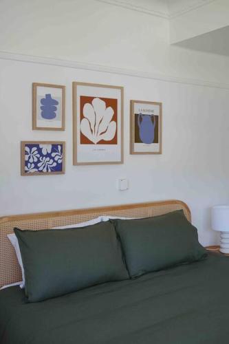 a bedroom with a bed with pictures on the wall at Sunset Beach House in Soldiers Point