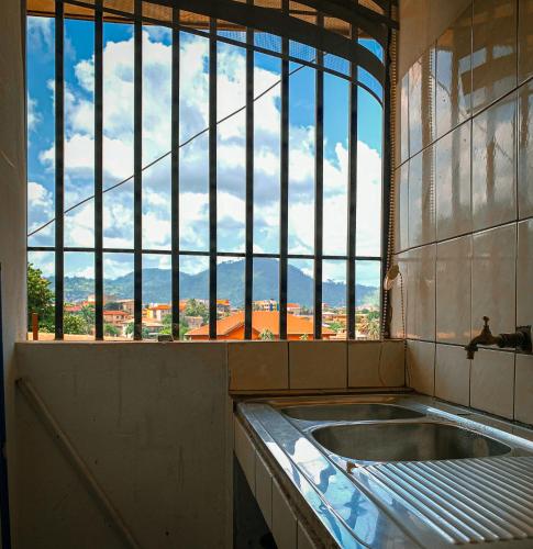 una vasca da bagno in una stanza con una grande finestra di Appartement élégant proche de Yaoundé Centre a Yaoundé