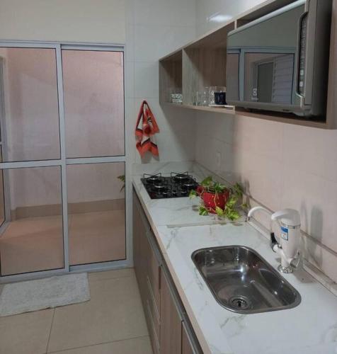 a small kitchen with a sink and a stove at Flat Morada da Neblina! in Chapada dos Guimarães