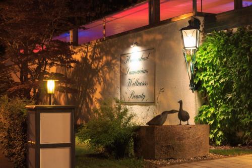 two birds sitting on a bench in front of a building at Garden Hotel Reinhart in Prien am Chiemsee