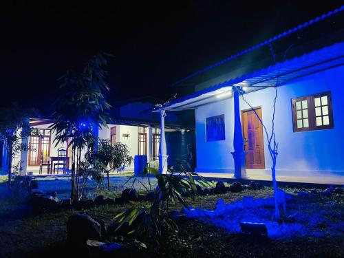 een huis verlicht in de nacht met blauwe lichten bij JM resort in Trincomalee