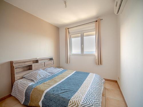 een slaapkamer met een bed en een raam bij T2 Équipé - bas de la possession in La Possession