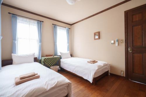 a room with two beds and a window at Lodge Kent in Hokuto