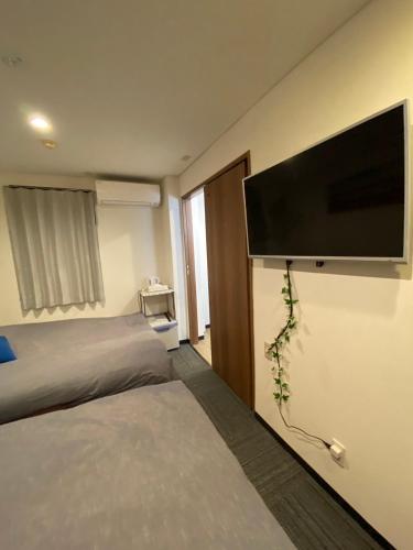 a hotel room with a flat screen tv on the wall at MR TOMO FUJI in Fuji