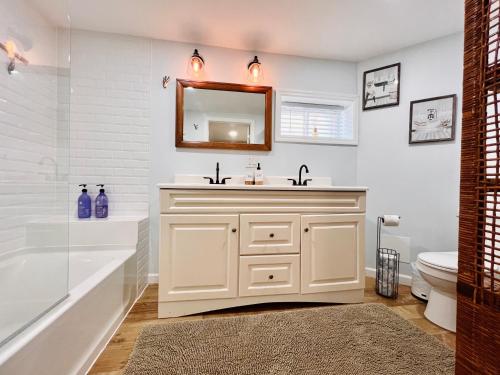 a bathroom with a sink and a mirror at Ultra Modern - Entire 3 Bedroom Apartment - 5 min walk to the Beach in Wildwood