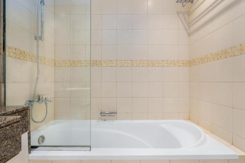 a bathroom with a tub with a glass shower at Perfect 2BD apartment in the heart of Marina - top spot in Dubai