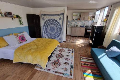 a bedroom with a bed and a couch and a kitchen at Aparta estudio Colorido in Bogotá