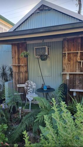 a house with a table and a chair in a garden at JDs Tropical stays in Cairns