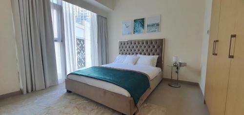 um quarto com uma cama e uma grande janela em SVIZONA Premium 2 Bed I Panoramic Creek Views em Dubai