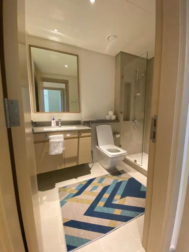 a bathroom with a toilet and a sink and a mirror at SVIZONA Premium 2 Bed I Panoramic Creek Views in Dubai