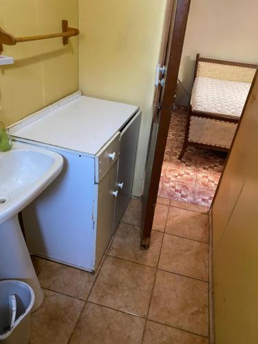 Elle comprend une petite salle de bains pourvue d'un réfrigérateur blanc et d'un évier. dans l'établissement Apartamento con 3 dormitorios para 8 personas con quincho, à Loncura