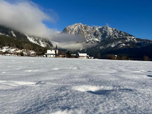 a snow covered field with a mountain in the background at Haus Frey in Altaussee