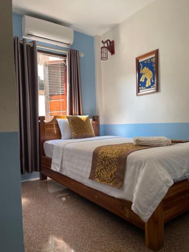 a bedroom with two beds and a window at Liberty Place in Luang Prabang