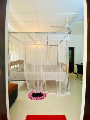a bedroom with a bed with white drapes at Sun Vivanta Resort in Mirissa