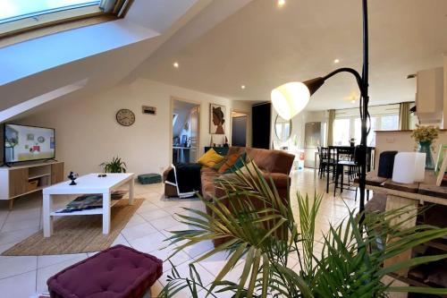 a living room with a couch and a table at 10min Bus Strasbourg centre-Parking Privé-WiFi-TV in Bischheim