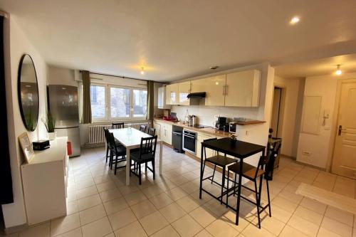 a kitchen with a table and chairs in a room at 10min Bus Strasbourg centre-Parking Privé-WiFi-TV in Bischheim