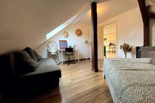 Bischheim的住宿－Strasbourg-Chaleureux-PARKING-Wifi-Tv，一间卧室配有一张床、一张沙发和一张桌子