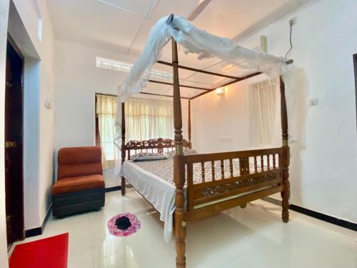 1 dormitorio con cama con dosel y silla en Sun Vivanta Resort, en Mirissa