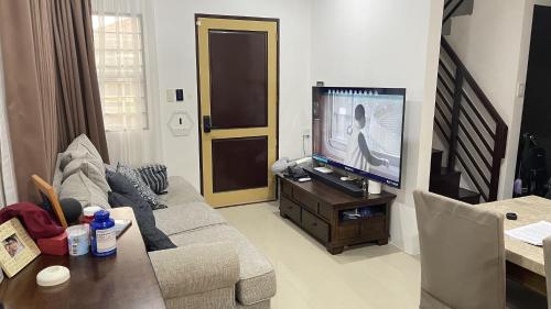 a living room with a couch and a flat screen tv at Exclusive Midori Paradise in Minglanilla