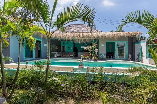 een huis met een zwembad en palmbomen bij Balifornia Villa Canggu in Canggu