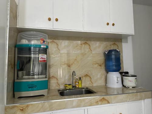 a kitchen counter with a coffee maker and a sink at My Lovely Apartment in Dipolog
