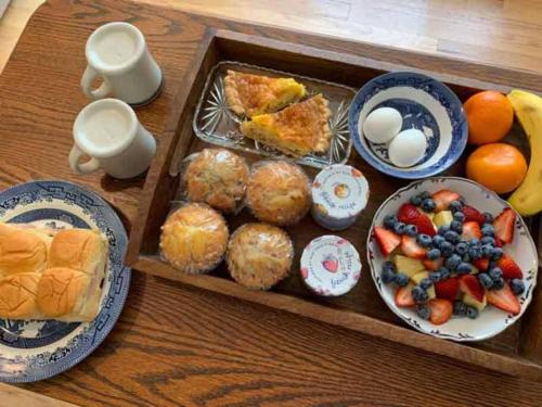 a tray of food with muffins and fruit on a table at Bluebirds Nest 10 Min to AVL Biltmore hot tub cont bkfst sparkling water in Asheville