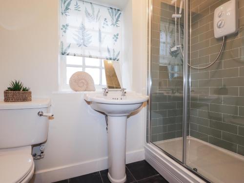 a bathroom with a sink and a shower at Lydia Cottage - Cromarty in Cromarty