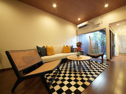 a living room with a couch and a checkered rug at Osaka MiKa Garden family house direct KIX airport in Osaka
