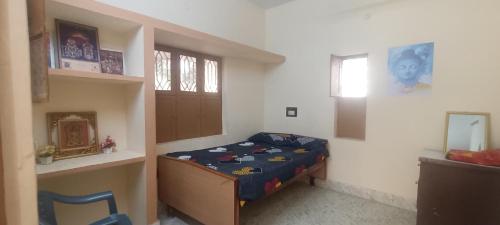 ein kleines Schlafzimmer mit einem Bett in einem Zimmer in der Unterkunft ANBU RAMANA Guest House in Tiruvannāmalai