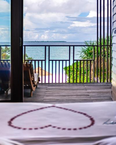 a room with a table with a view of the ocean at The Barefoot Eco Hotel in Hanimaadhoo