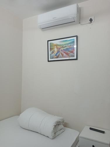 a white room with a bed with a picture on the wall at Hotel In Need - Near to the US France Italy Saudi Embassy and Airport in Dhaka