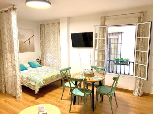 マラガにあるAnas Apartment centro históricoのベッド、テーブル、椅子が備わる客室です。