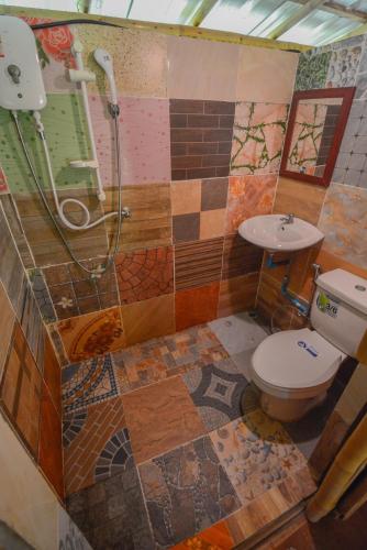 a bathroom with a shower and a toilet and a sink at Ratanaporn Green in Phuket