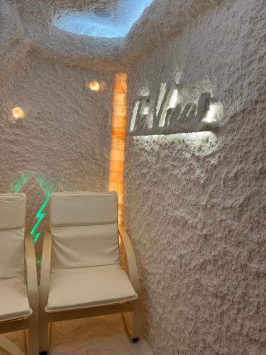 two chairs in front of a wall with graffiti at Family Hotel The View & SPA in Tsigov Chark