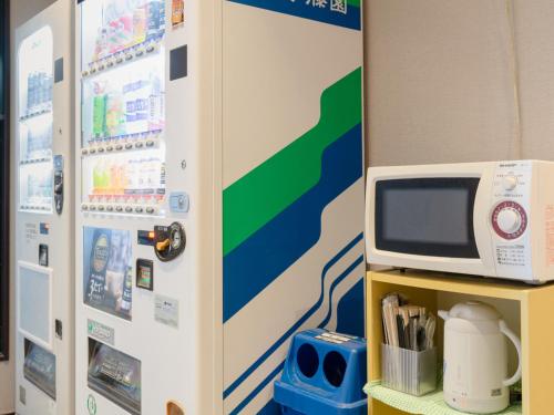 a refrigerator with a microwave on top of a shelf at Toyama Town Hotel in Toyama