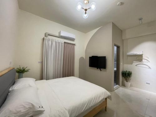 a bedroom with a bed and a flat screen tv at 慢慢相遇 in Taitung City