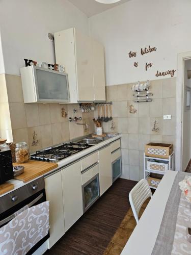 a kitchen with white cabinets and a stove top oven at Appartamento Citara in Ischia