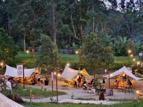 um grupo de pessoas em tendas em um parque à noite em Sungai Tiny House 2 em Raub