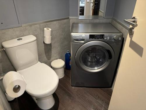 a bathroom with a toilet and a washing machine at ALTAMIRA (Paris Expo - Porte de Versailles) in Issy-les-Moulineaux