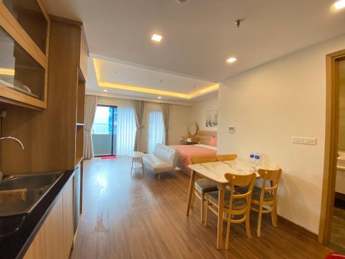 a kitchen and living room with a table and a bed at FLC Sea Tower Condotel in Quy Nhon