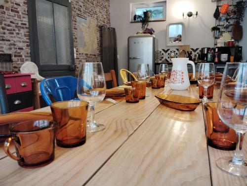 - une longue table en bois avec des verres à vin dans l'établissement La cabane des pêcheurs, à Pont-d'Ouilly