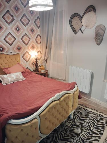 une chambre avec un grand lit avec une couverture rouge dans l'établissement La cabane des pêcheurs, à Pont-d'Ouilly