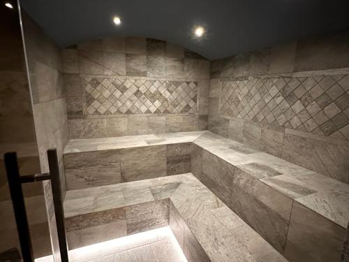 een grote badkamer met een groot stenen bad bij "Park Hotel Ela" in Borovets