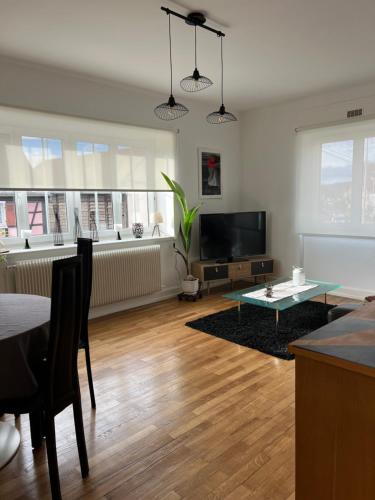 un salon avec une table et une télévision dans l'établissement Location chez marie, à Horbourg-Wihr