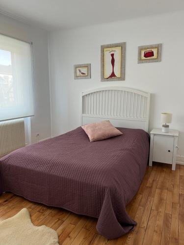 1 dormitorio con 1 cama grande con manta morada en Location chez marie, en Horbourg