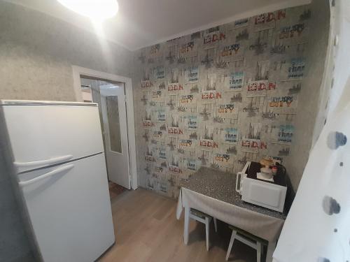 a kitchen with a white refrigerator and a table with a table sidx sidx at Квартира біля центрального парку, район Покровського собору на Княгині Ольги 13 in Rivne